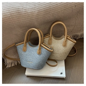 Detail of light blue and beige plush textured bucket bags with leather handles and straps