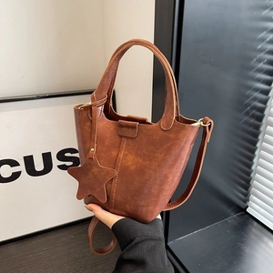 Sac seau marron en similicuir avec breloque étoile et bandoulière, décor moderne