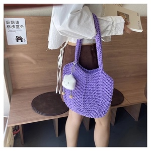 Macro detail of purple knit tote bag with thick texture and white cloud charm