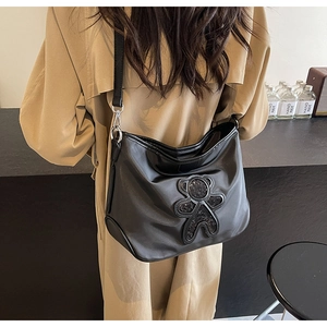 Détail du sac de voyage en nylon noir avec ours en paillettes et bandoulière réglable