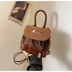 Detail eines Vintage Mini-Rucksacks in Braun mit Dackel-Patch und Kordelzugverschluss