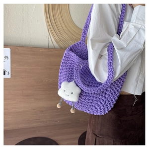 Detail of purple hand-knitted crochet shoulder bag with cute cloud plush pendant