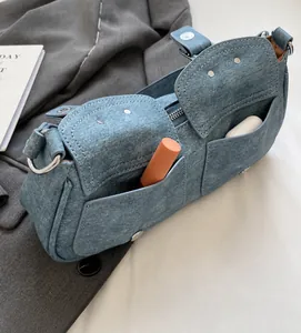 Detailansicht der hellblauen Denim-Schultertache mit doppelten Taschen und Metallring