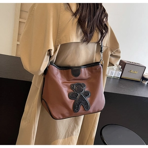 Vue détaillée du dos d'un sac bandoulière marron en nylon avec patch ours en paillettes