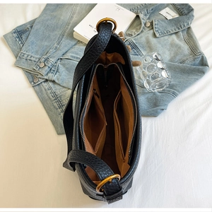 Interior view of large capacity black bucket bag with multiple pockets and gold hardware