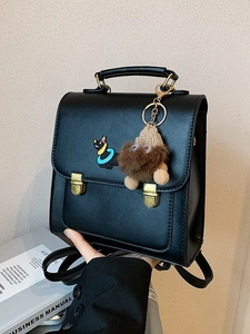 Black matte leather backpack with puppy embroidery and plush charm in hand