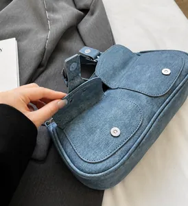 Details der hellblauen Denim-Schultertasche mit silbernen Beschlägen und Taschen