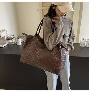 Detailed macro view of high-quality brown woven leather texture and reinforced bag corners