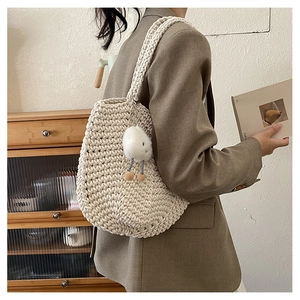 Detail of crochet cotton bag with cloud charm accessory and woven texture detail