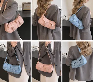 Modell zeigt Vintage-Unterarmtasche mit Doppeltaschen und silbernen Schnallen