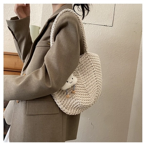 Detail of cream woven shoulder bag with cloud charm and honeycomb knit texture