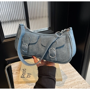 Nahaufnahme der hellblauen Denim-Baguette-Tasche mit zwei Vordertaschen und Schnallen