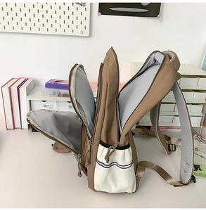 Vue détaillée du sac à dos kaki avec compartiments zippés et dos en maille respirante