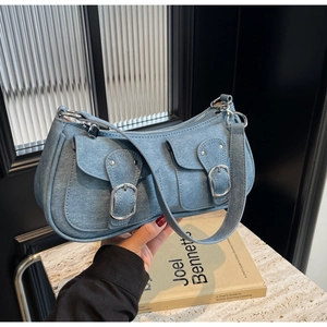 Detail der blauen Denim Baguette Tasche mit doppelten Klappentaschen und Silberschnallen