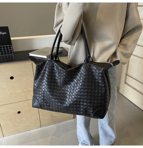 Close-up of the intricate woven leather texture on a large black tote bag