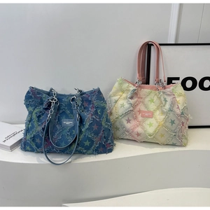 Détail du sac cabas en jean avec motif étoile, bords effilochés et anses en chaîne