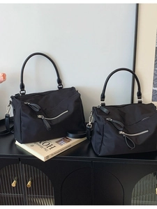 Two black nylon Boston handbags in large and small sizes with metallic zip details