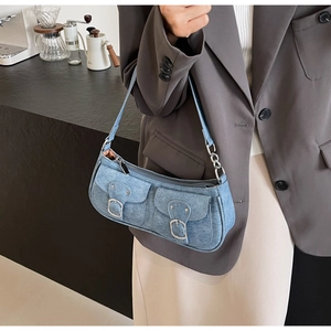 Detail der hellblauen Denim-Schultertasche mit zwei Vordertaschen und Metallschnallen