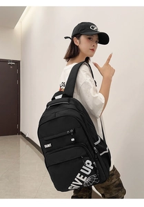 Close-up of black backpack with white SUNT and GIVE UP letter print and zip pockets