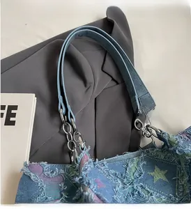 Détail du sac cabas en denim à motif d'étoiles avec bords frangés et poignée à chaîne