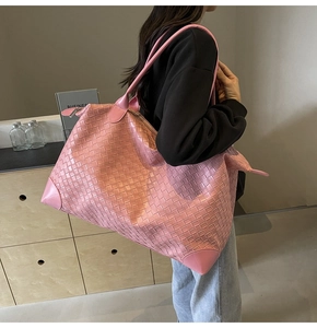 Side view of pink woven leather tote bag shown in a minimalist interior scene