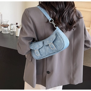Details der hellblauen Denim-Baguette-Tasche mit Doppeltaschen und Silberschnallen