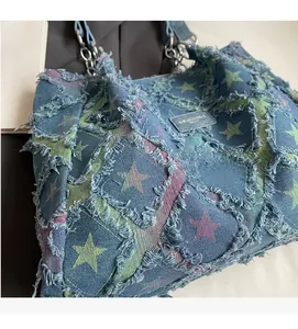 Gros plan du sac cabas en jean avec étoiles colorées et broderies à bords effilés