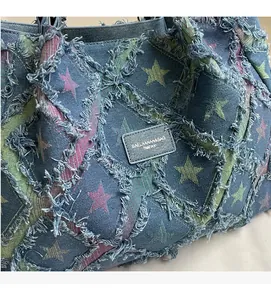 Détails de motifs étoiles et bords effilochés sur cabas en denim avec écusson cuir
