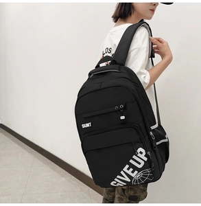 Side view of student wearing black backpack with white GIVE UP print and wide straps