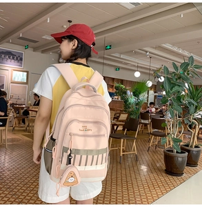 Vue détaillée d'un sac à dos rose en toile avec porte-clé pizza et imprimé Have a Good Day