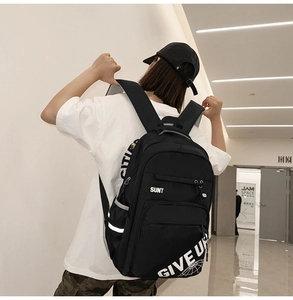 Detail of black nylon backpack with reflective safety strip and white letter printing