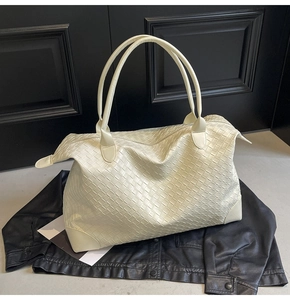 Close-up detail of off-white woven texture on a large minimalist tote bag