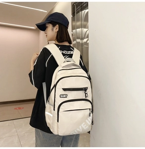 Off-white large capacity student backpack shown from a side-rear view on a model