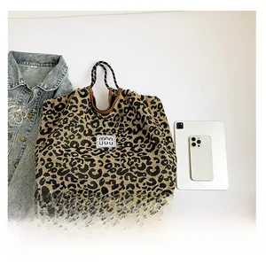 Macro detail of leopard print tote bag with woven handles and spacious interior capacity