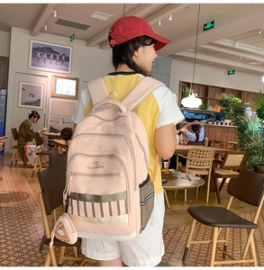 Détail du sac à dos scolaire rose clair avec broderie et charmant pendentif en peluche