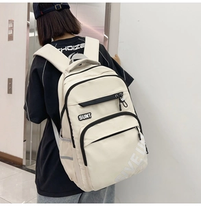 Detailed back view of a minimalist cream-colored backpack with stylish letter embroidery