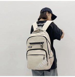 Creamy white multi-pocket school backpack shown on a model for casual student wear