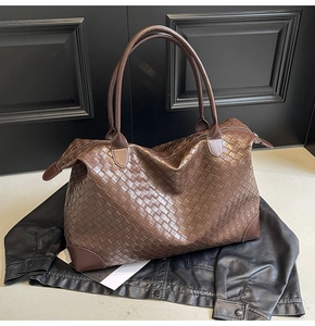 Detailed close-up of dark brown woven texture and reinforced leather corners on tote bag
