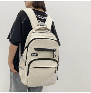 Detailed view of the large-capacity beige nylon backpack with multiple storage pockets
