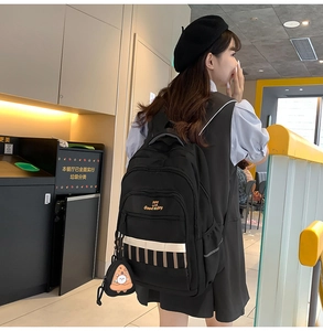Détail d'un sac à dos noir pour l'école avec imprimé d'ours et bretelles réglables