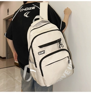 Detail view of beige nylon backpack with GIVE UP side print and multiple zipper pockets