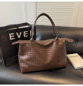 Detailed view of woven leather texture and reinforced corners on dark brown tote bag