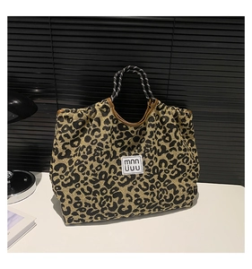 Detail of leopard print tote bag with woven rope handles and textured jacquard fabric