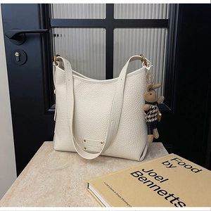 Macro shot of off-white lychee pattern leather and a cute bunny charm on bucket bag