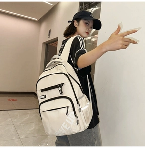 Close-up of white nylon backpack featuring SUNT logo and functional multi-pocket design
