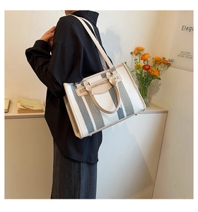 Detail van de wit-groene gestreepte canvas shopper met leren riem en ritssluiting