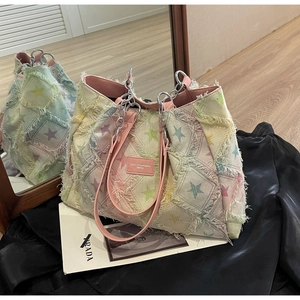 Détail d'un sac cabas patchwork coloré avec étoiles, bords effilochés et anse chaîne