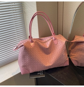 Close-up of pink woven leather tote bag showing intricate wide-strip craft and texture