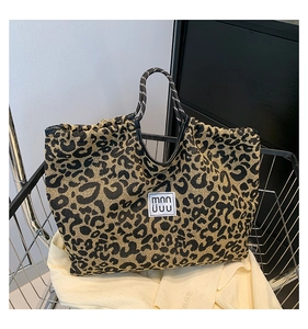 Detail of leopard print tote bag with woven handles inside a metallic shopping basket