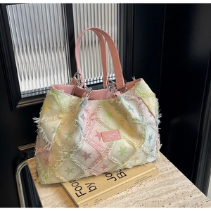 Détail du sac cabas à étoiles arc-en-ciel avec anses en cuir rose et bords frangés